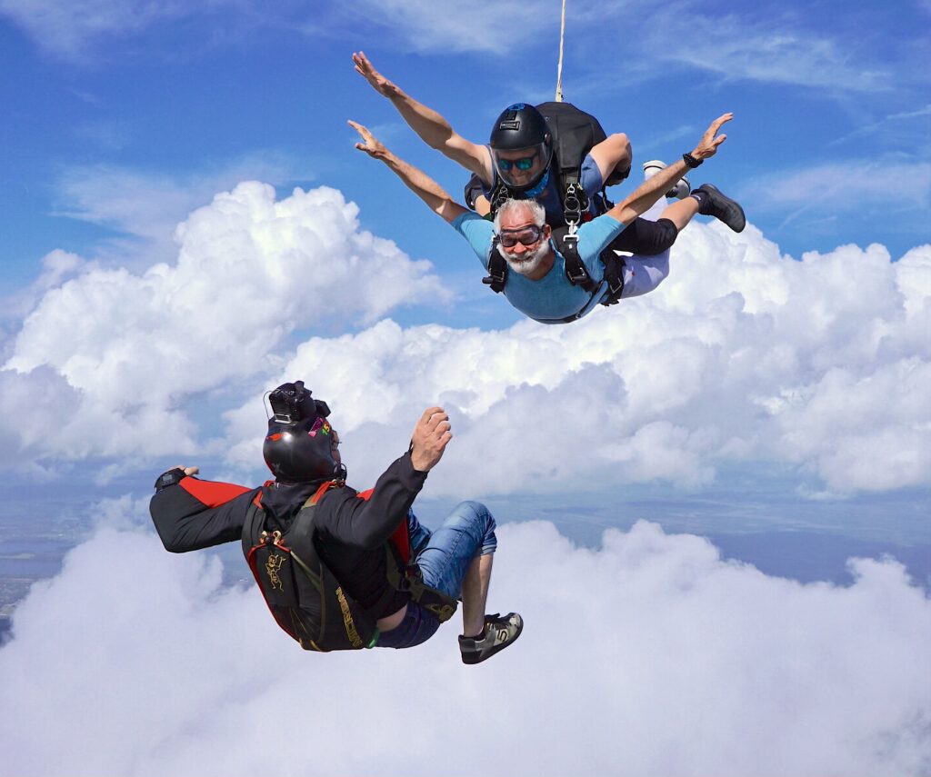 tandem pair in freefall with a skydiving videographer capturing their jump