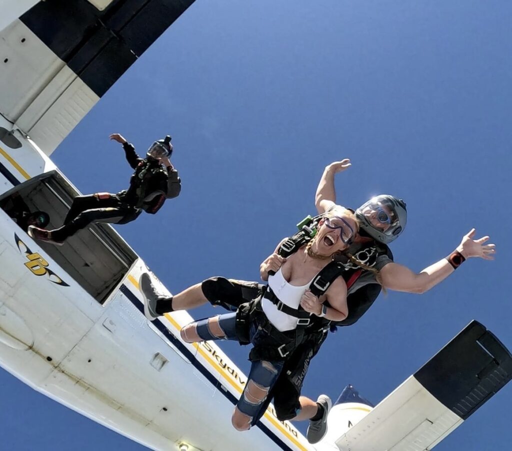 Tandem skydiving pair exit a twin otter at Skydive DeLand